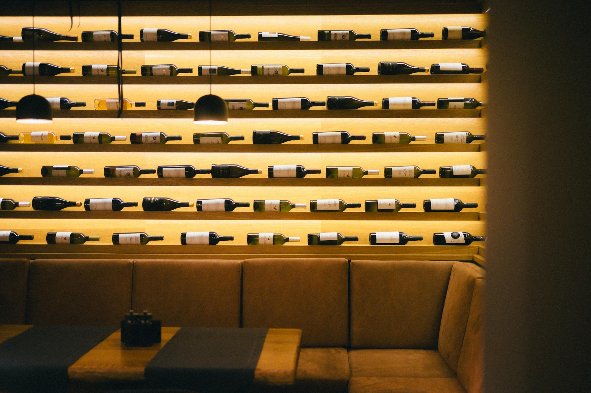Lorbeer — Modernes Wirtshaus Interieur mit Weinregal und warmem Licht